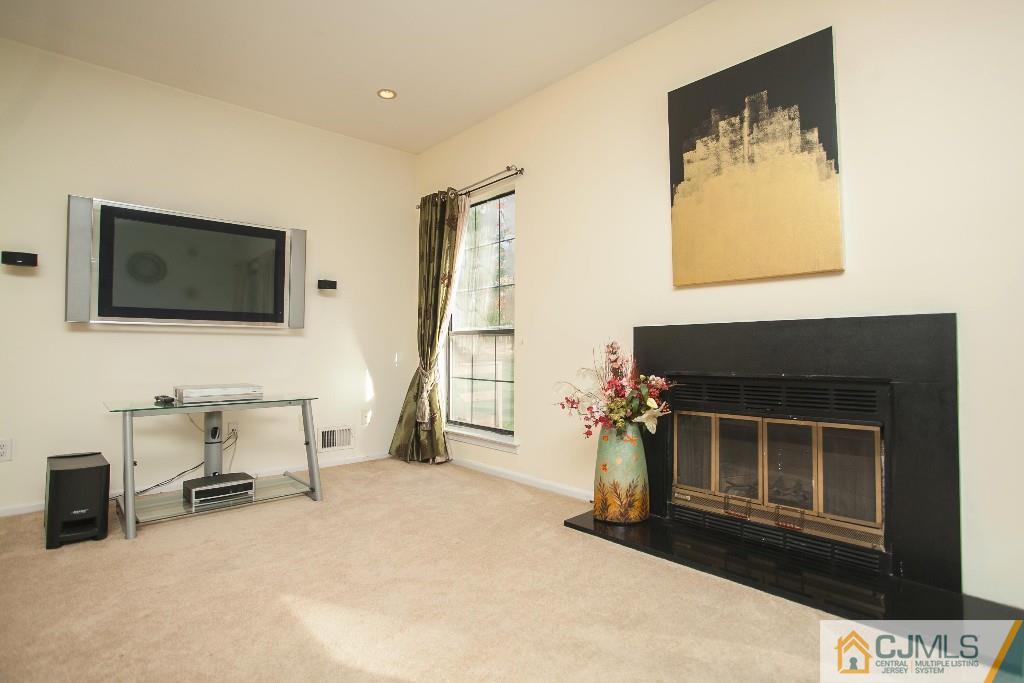 1006 Timber Oaks Road Edison, NJ 08820 - Photo 8 of 13 a living room with a fireplace furniture and a flat screen tv