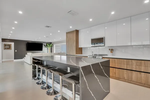 a kitchen with stainless steel appliances a stove a sink a microwave a refrigerator and cabinets