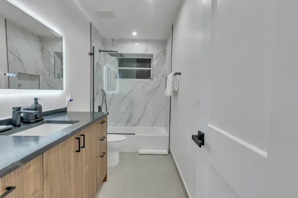 a bed room with a bed and a view of kitchen
