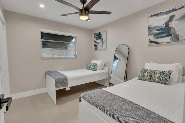 a bedroom with two beds and painting on the wall