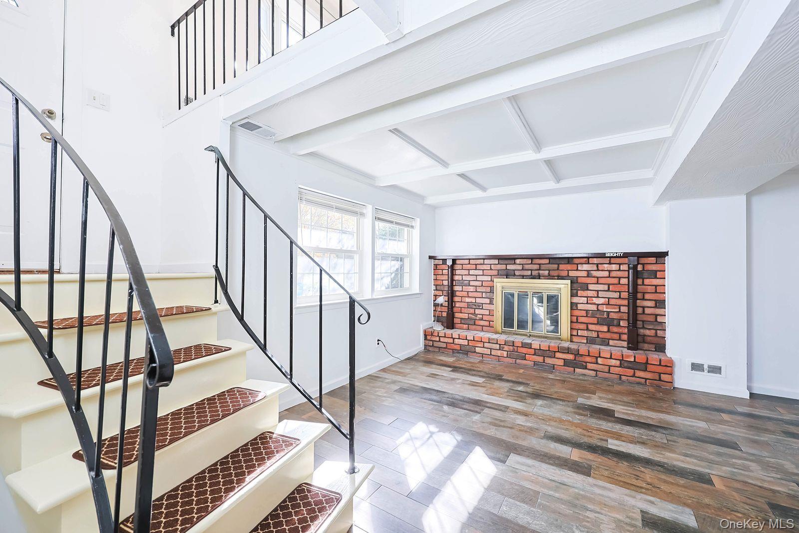 15 Mayflower Lane East Setauket, NY 11733 - Photo 13 of 23 a view of an empty room with wooden floor and stairs