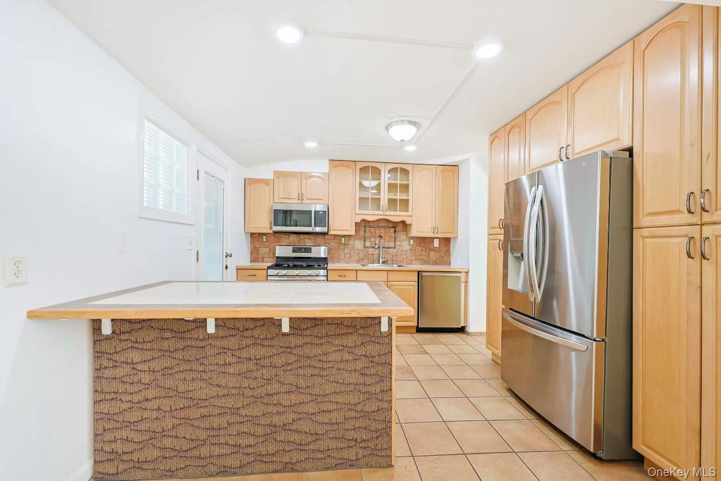 15 Mayflower Lane East Setauket, NY 11733 - Photo 7 of 23 a kitchen with stainless steel appliances granite countertop a refrigerator a stove a sink and a refrigerator