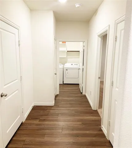 a view of a hallway with wooden floor and entryway