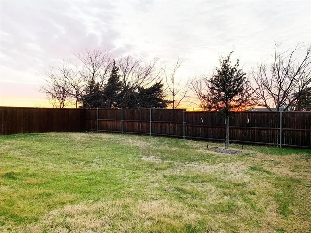 a view of a yard with wooden fence