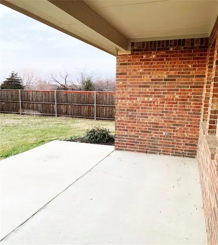 a view of a yard with wooden fence