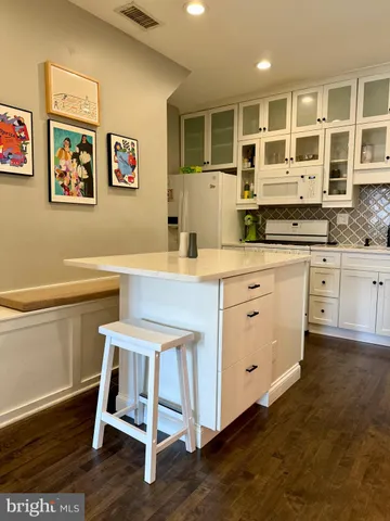 a dining room with wooden floor and white walls