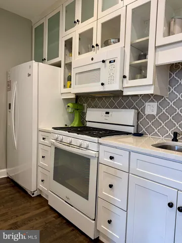 a white stove top oven sitting inside of a kitchen