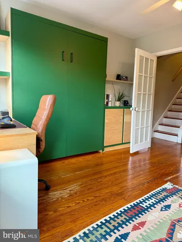 a view of a kitchen with fridge and wooden floor