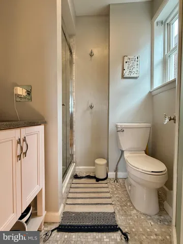 a bathroom with a toilet and a mirror