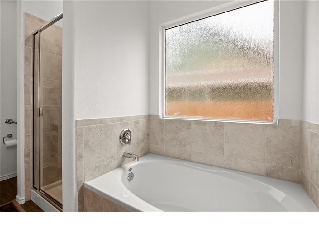 328 Majestic Cedar Court Liberty Hill, TX 78642 - Photo 14 of 31 a bathroom with a bathtub and a shower