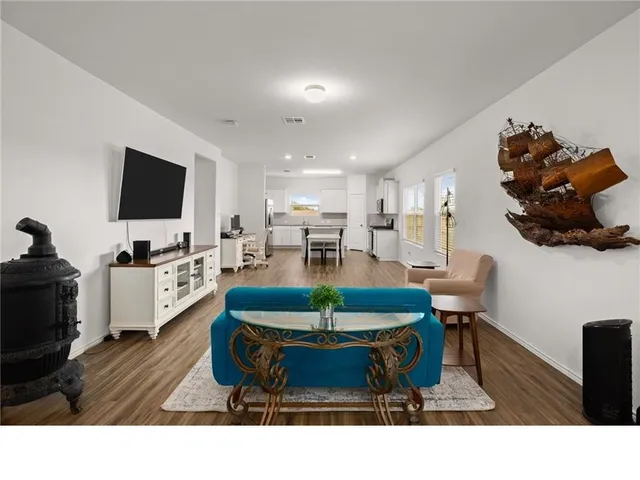 a living room with furniture a flat screen tv and a dining table