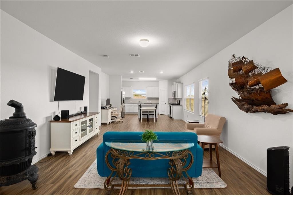 328 Majestic Cedar Court Liberty Hill, TX 78642 - Photo 5 of 31 a living room with furniture a flat screen tv and a dining table