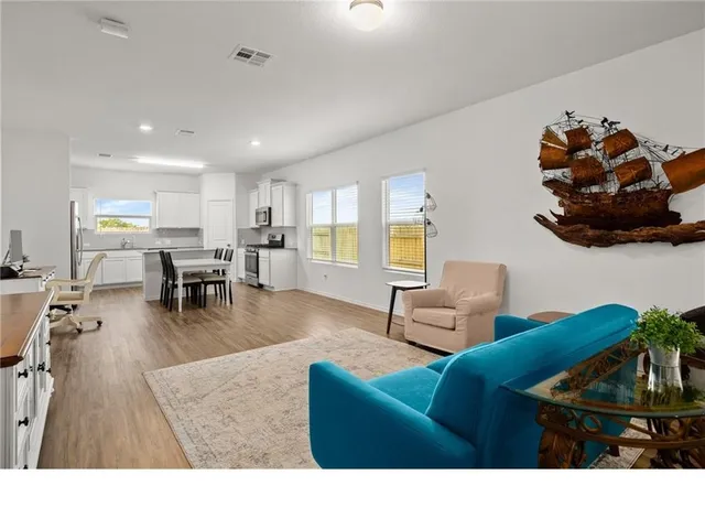 a living room with furniture and a dining table