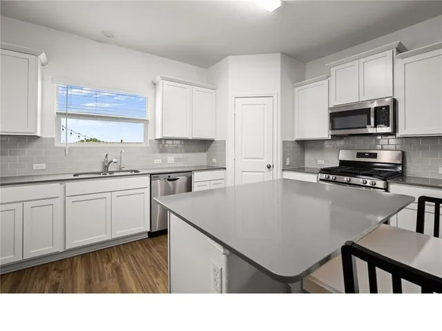 a kitchen with a sink a stove a microwave and cabinets