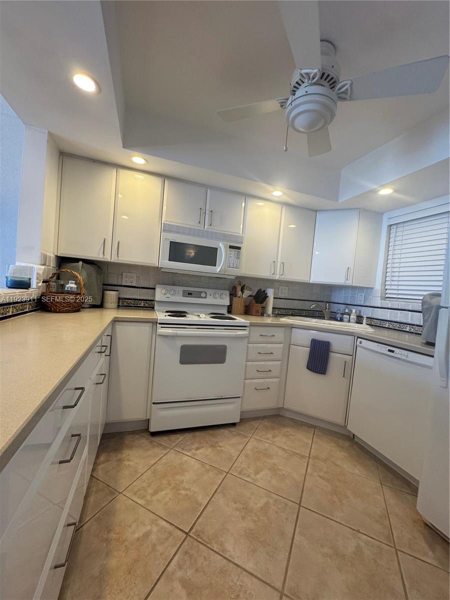 400 North Surf Road, Unit RGB Hollywood, FL 33019 - Photo 6 of 17 a kitchen with cabinets a sink and white appliances