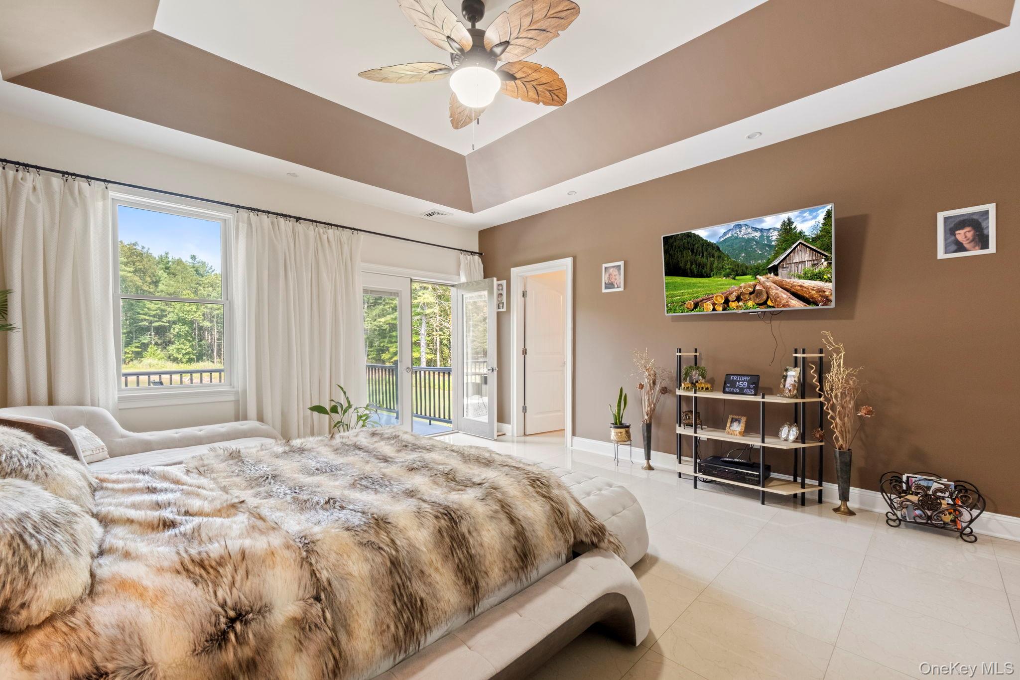 174 Webber Road Coxsackie, NY 12058 - Photo 36 of 50 a bedroom with a bed a chandelier and a flat screen tv