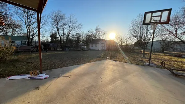 a view of a house with large tree and wooden fence