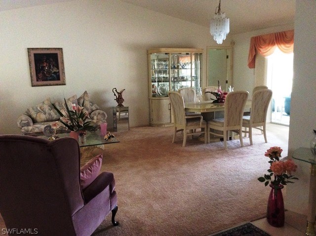 225 Danby Road Lehigh Acres, FL 33936 - Photo 12 of 20 a living room with furniture a window and a chandelier