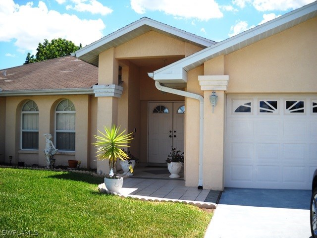 225 Danby Road Lehigh Acres, FL 33936 - Photo 2 of 20 a front view of a house with garden