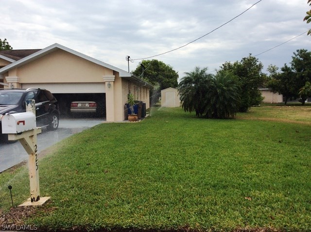 225 Danby Road Lehigh Acres, FL 33936 - Photo 5 of 20 a front view of a house with garden