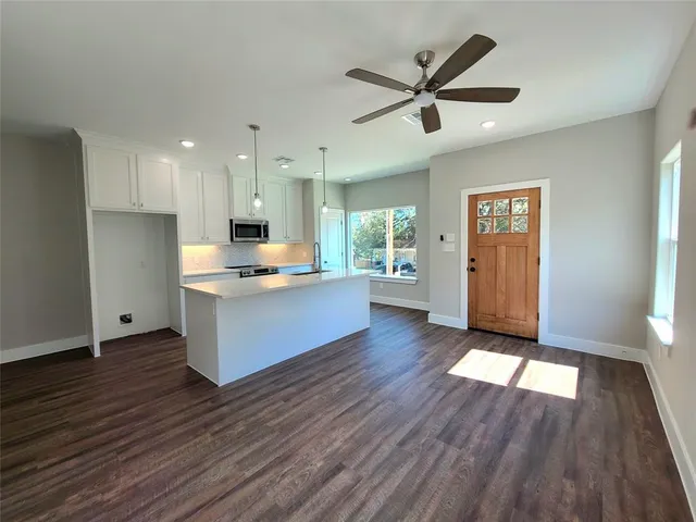 a view of a kitchen with wooden floor and a ceiling fan