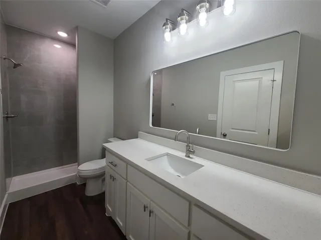 a bathroom with a sink a toilet and shower