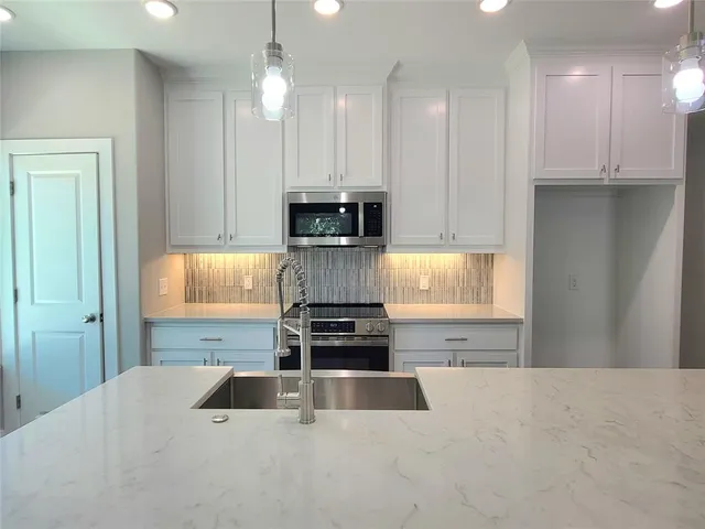 a kitchen with granite countertop a stove a sink and a granite counter tops