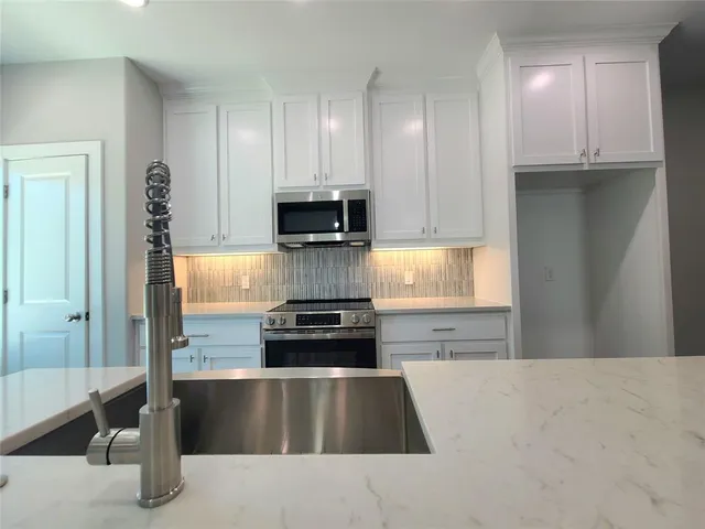 a kitchen with kitchen island granite countertop a stove and a refrigerator