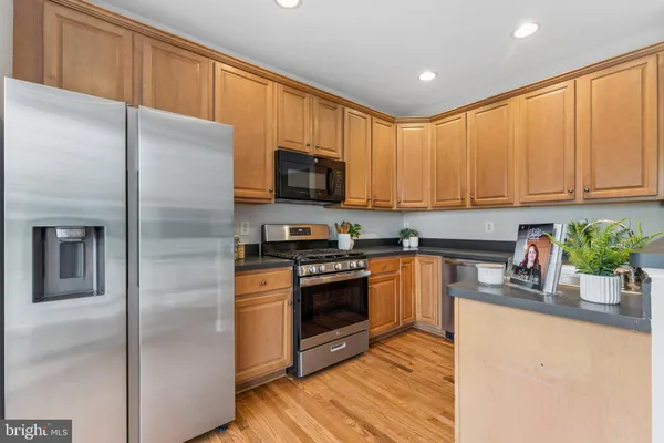a kitchen with stainless steel appliances granite countertop a refrigerator a stove top oven a sink and dishwasher