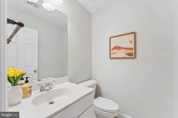 a bathroom with a sink vanity mirror and toilet
