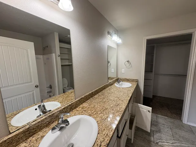a bathroom with a granite countertop sink and a mirror