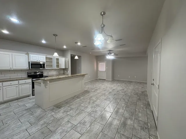 a large kitchen with kitchen island a sink stainless steel appliances and cabinets