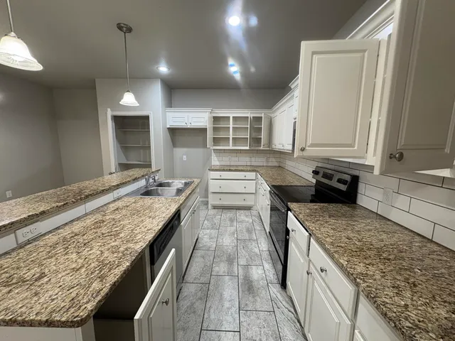 a kitchen with sink stove and cabinets