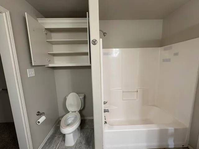 a bathroom with a toilet and a shower