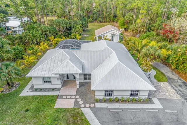 a aerial view of a house next to a yard with large trees