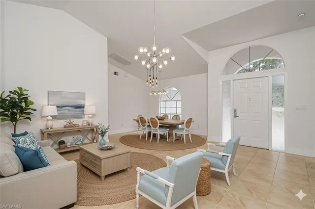 a living room with furniture a chandelier and a mirror