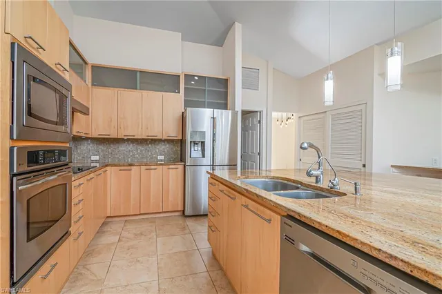 a kitchen with stainless steel appliances granite countertop a sink stove and cabinets