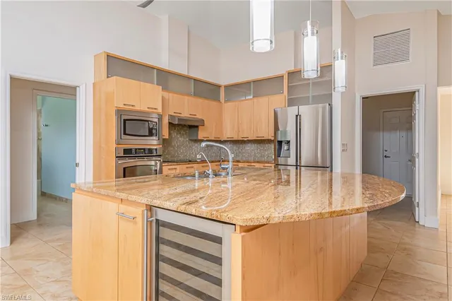 a kitchen with stainless steel appliances granite countertop a sink a stove and a refrigerator