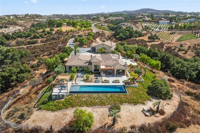 a view of a patio with couches and table and chairs with wooden floor and fence