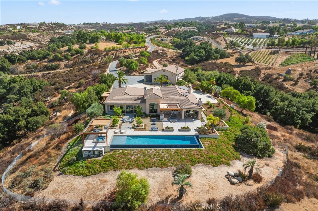 39893 Calle Breve Temecula, CA 92592 - Photo 2 of 70 an aerial view of a house with a garden and lake view