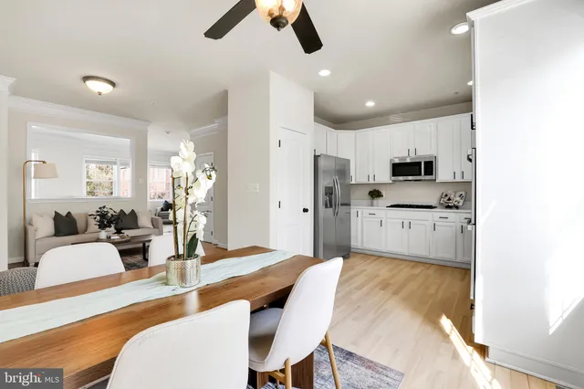 a large kitchen with cabinets a sink stainless steel appliances and dining table