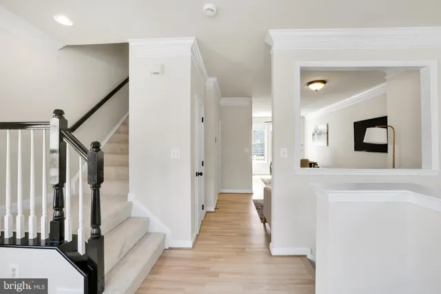 a view of a hallway with wooden floor and staircase
