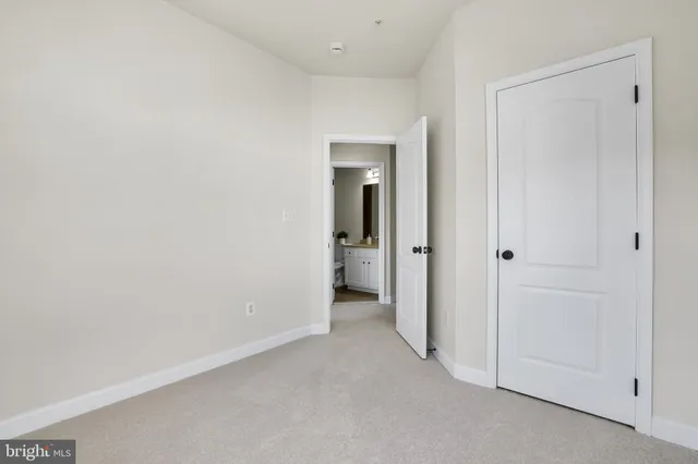 an empty room with closet and a bathroom
