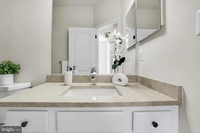 a bathroom with a granite countertop sink and a mirror
