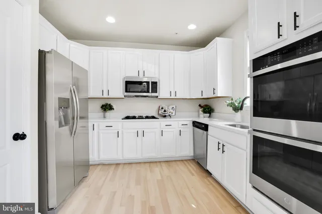 a kitchen with stainless steel appliances a refrigerator sink and microwave
