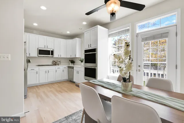 a large kitchen with granite countertop a sink stainless steel appliances and cabinets