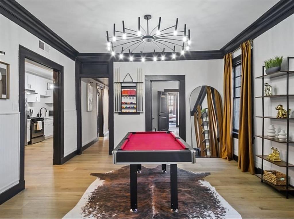 Recreation room featuring billiards table, ornamental molding, light wood-type flooring, and arched walkways