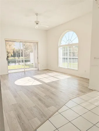 an empty room with wooden floor windows and outdoor view
