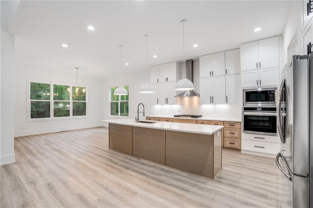 3766 Cheyenne Lane Jefferson, GA 30549 - Photo 10 of 52 a kitchen with stainless steel appliances granite countertop a stove top oven a sink dishwasher and a refrigerator with wooden floor