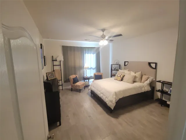 a spacious bedroom with a bed and a chandelier